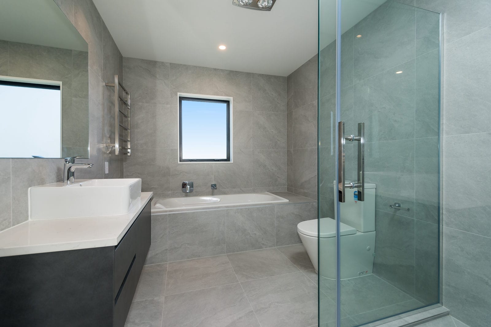 Bathroom with stone-look tiling, a freestanding vanity, bath and glazed shower, Orewa