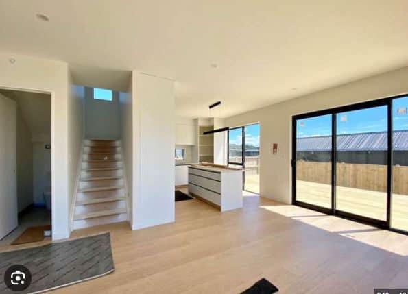 Entry looking past the stairs to the kitchen island and sliding doors, Orewa