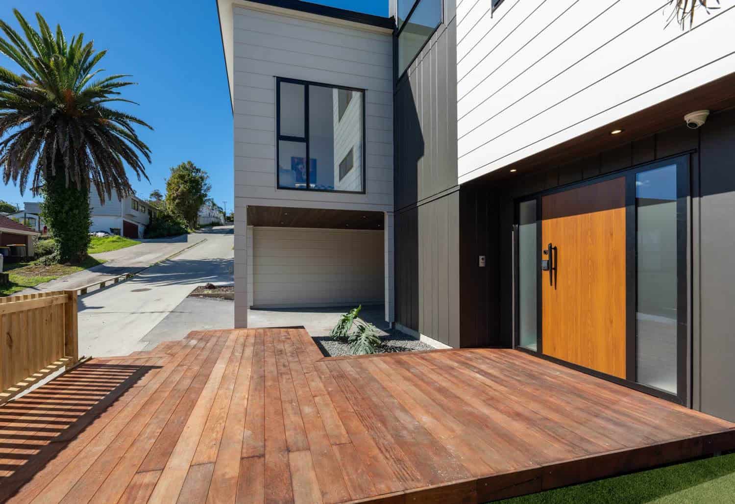 Hardwood entry deck leading to a timber front door with the garage alongside, Browns Bay