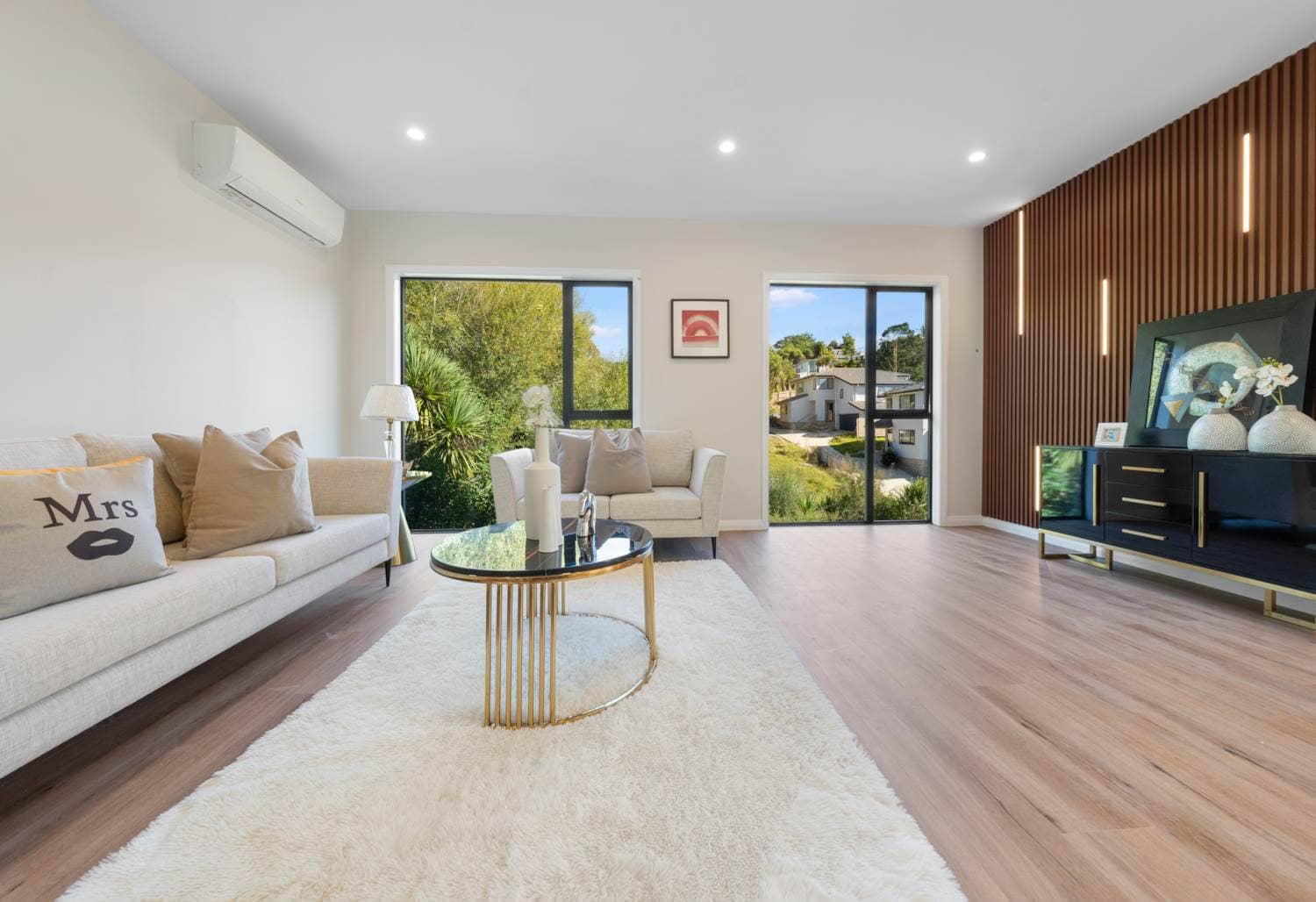 Living room with a vertical timber feature wall, sofas and a sliding door, Browns Bay