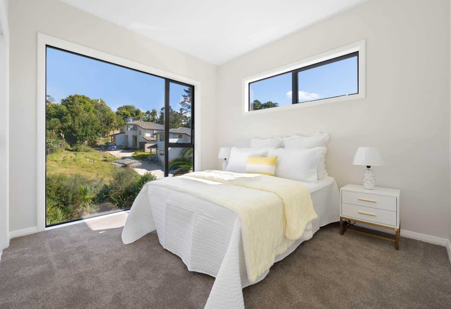 Bedroom with a corner window and a high window looking over the neighbourhood, Browns Bay
