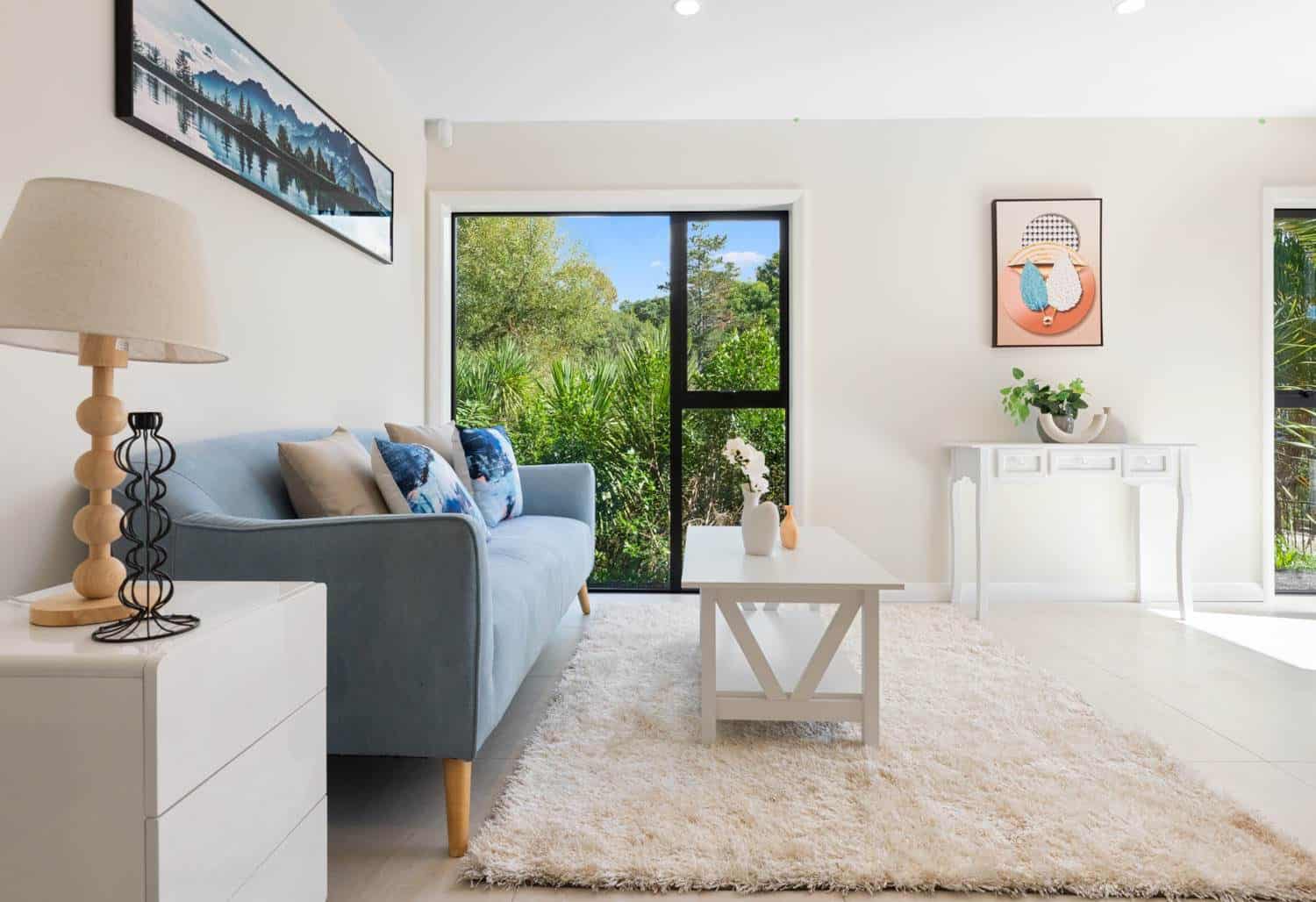 Living room with a grey sofa, rug and a sliding door to the garden, Browns Bay