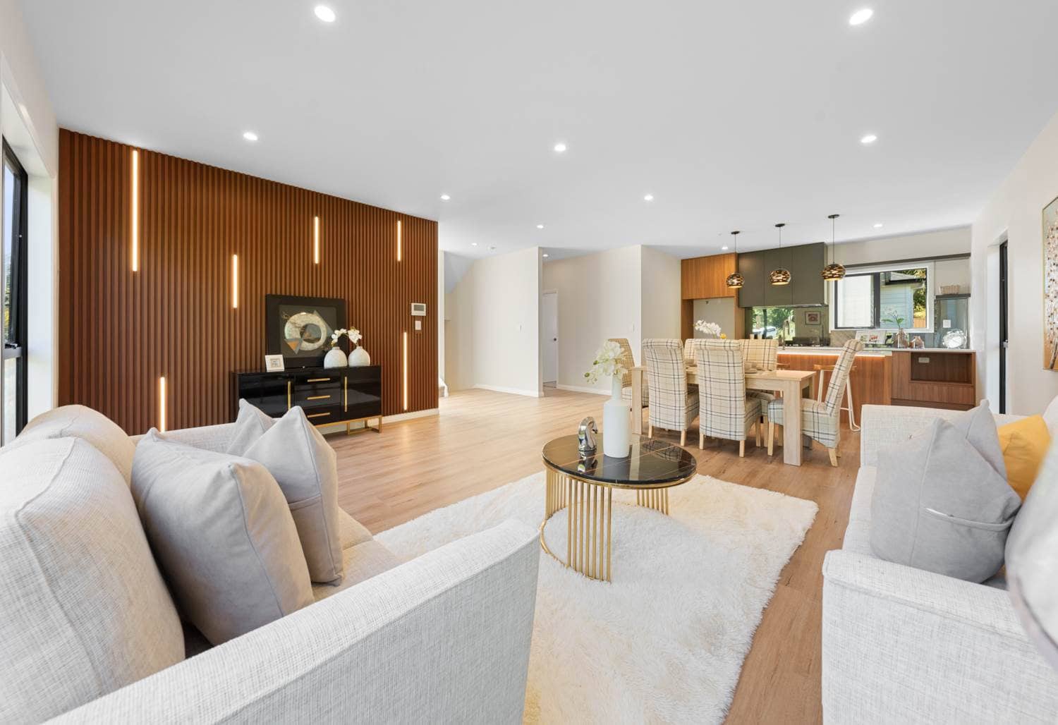 Living room with a full-height timber slat wall looking through to the dining area, Browns Bay