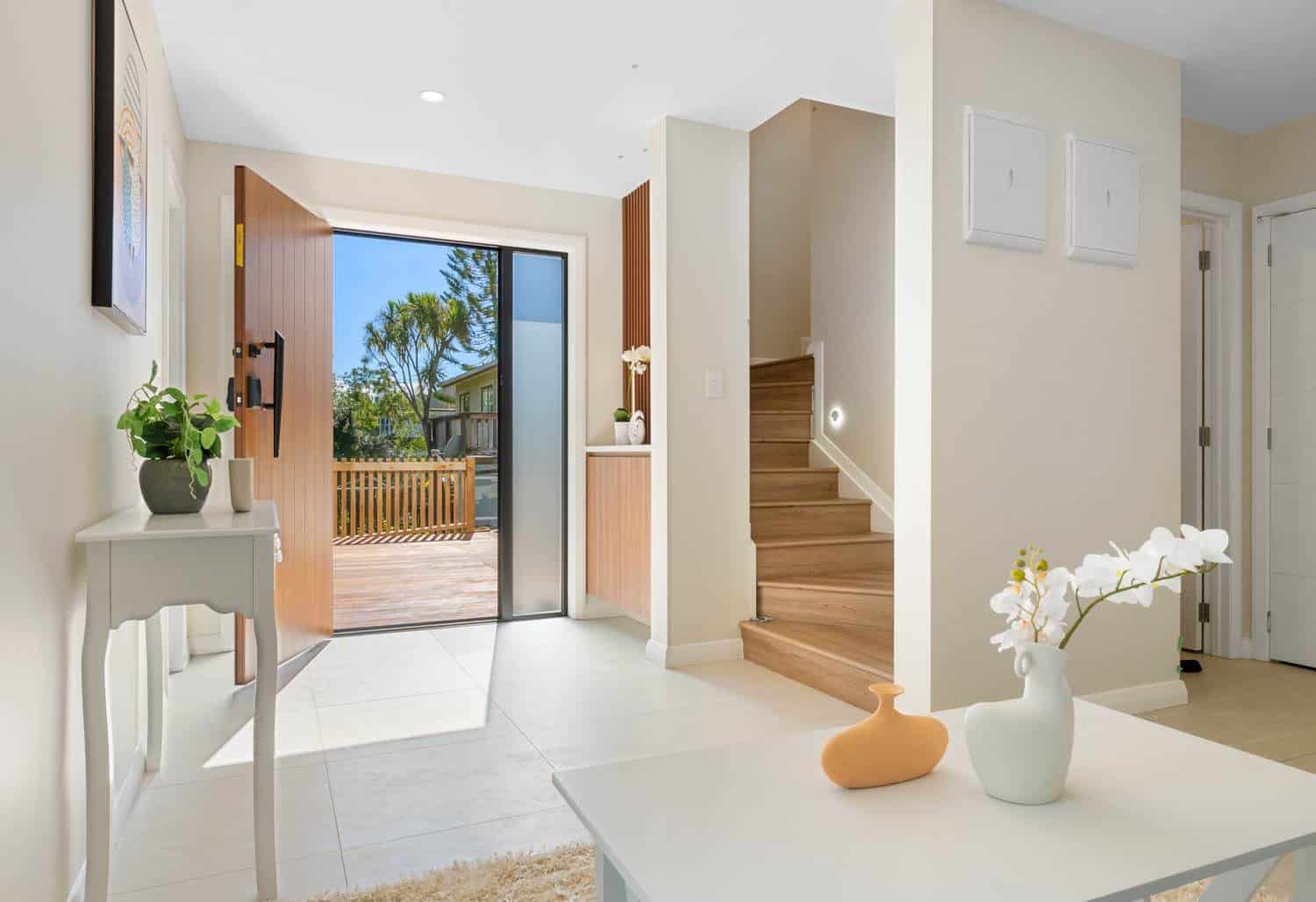 Entry hall with a console table, open front door and timber stair, Browns Bay