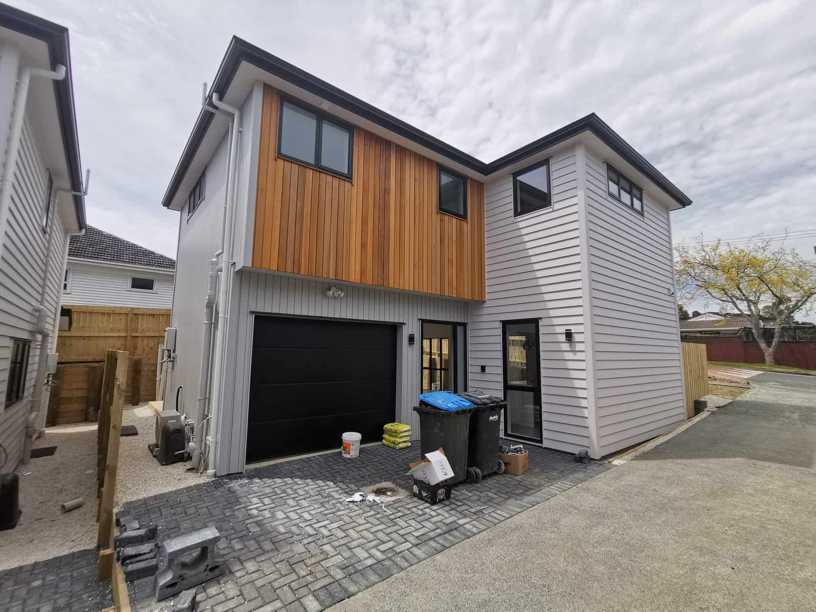 Newly built two-storey house with a timber-clad upper level and single garage, Blockhouse Bay