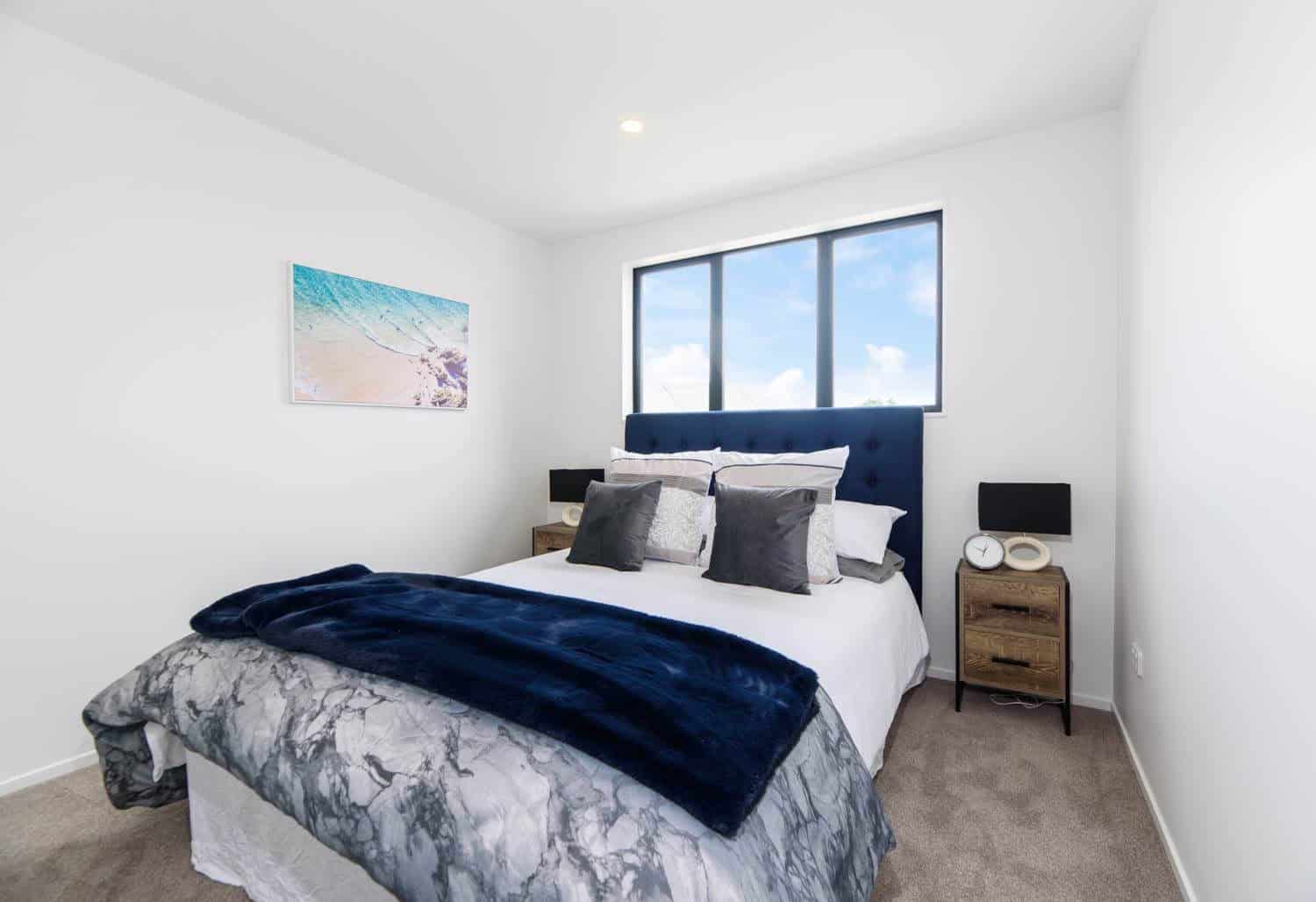 Bedroom with a navy upholstered bedhead and a high horizontal window, Blockhouse Bay