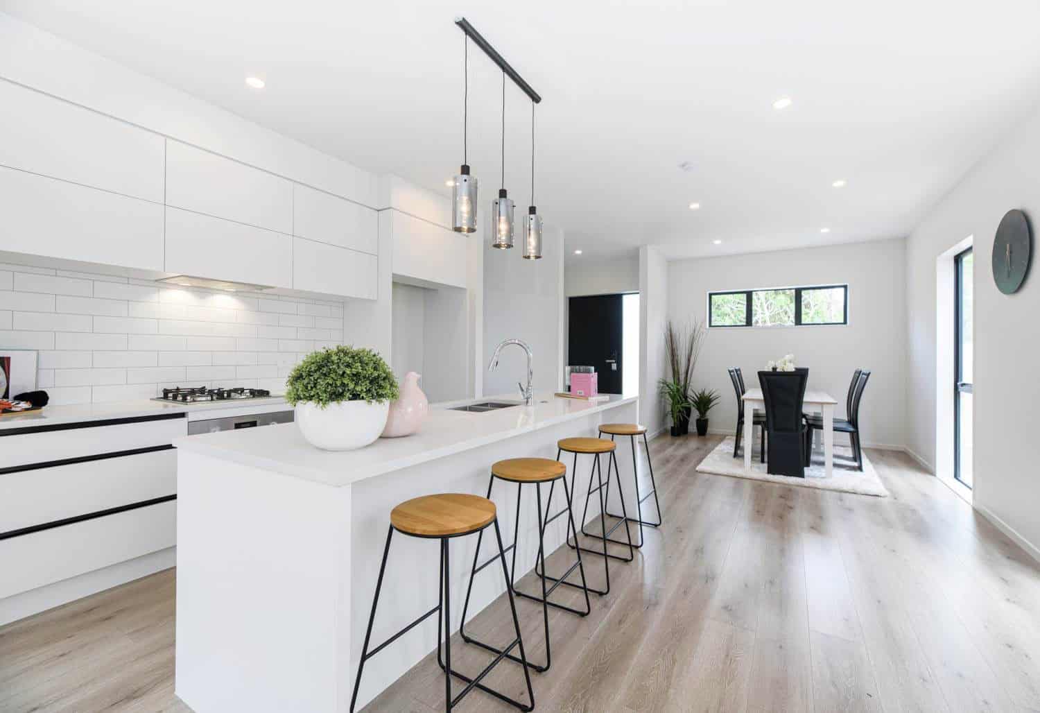 Kitchen island with timber stools looking through to the dining area, Blockhouse Bay