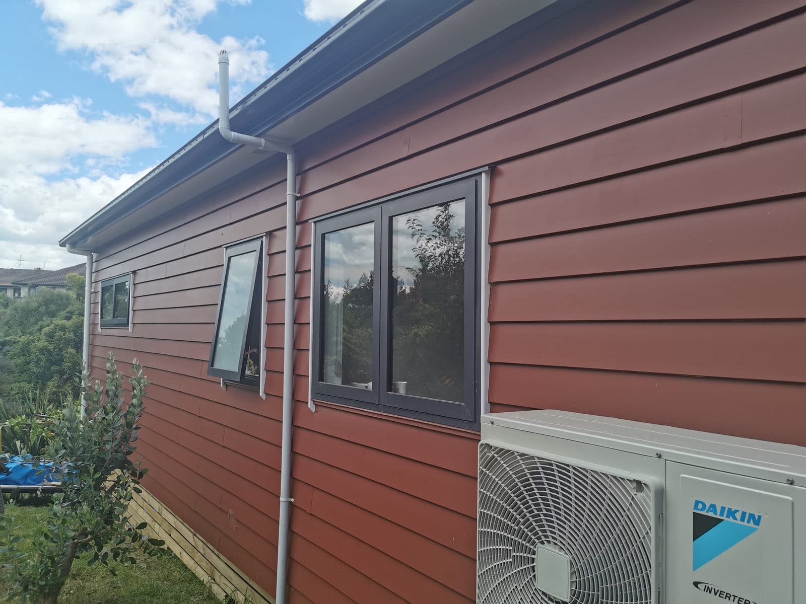 New red weatherboard cladding and windows across the extended elevation, Botany Downs