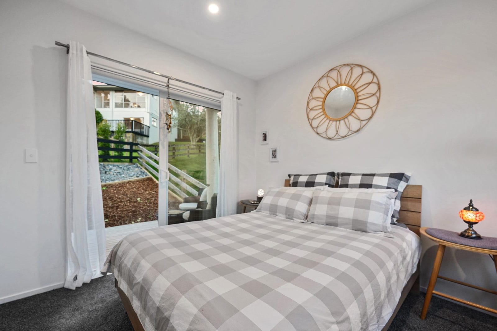 Bedroom with a sliding door to the deck and a round mirror above the bed, Coatesville