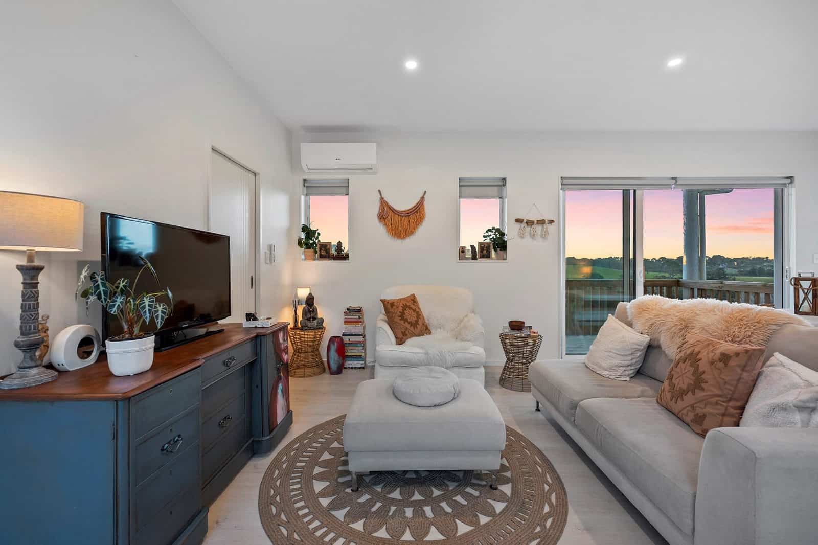 Living area with a sofa, television and sliding doors onto a rural outlook, Coatesville