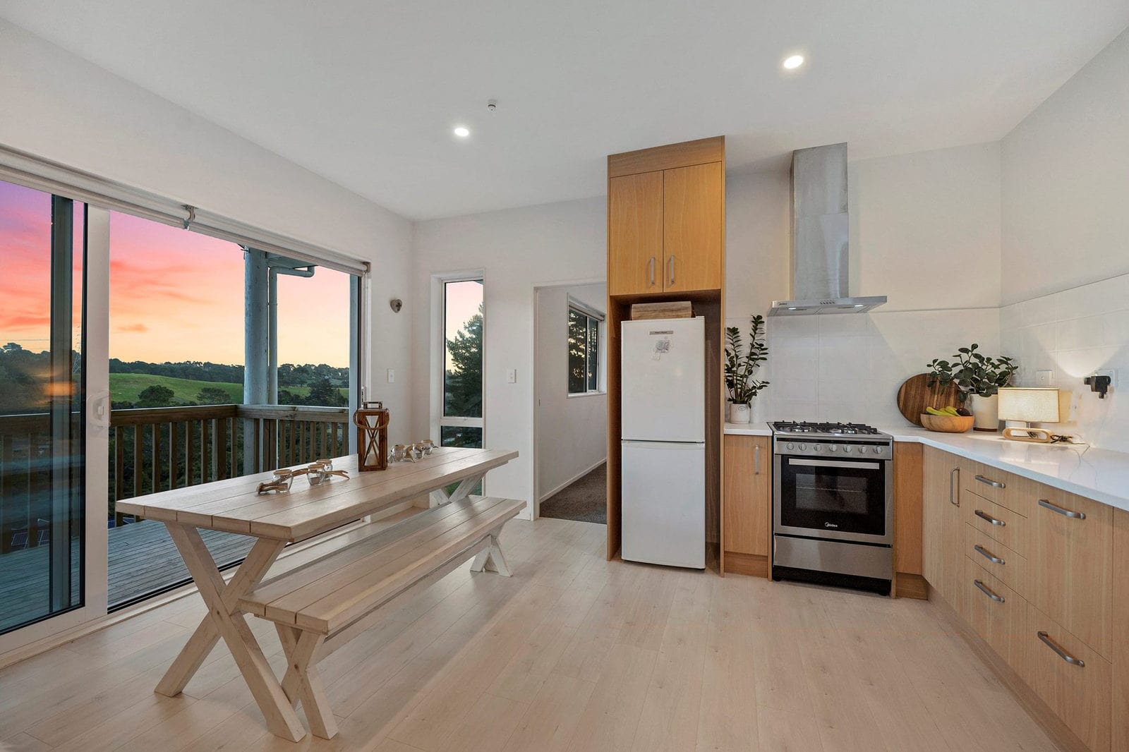 Kitchen and dining with a timber table and sliding doors to a rural view, Coatesville