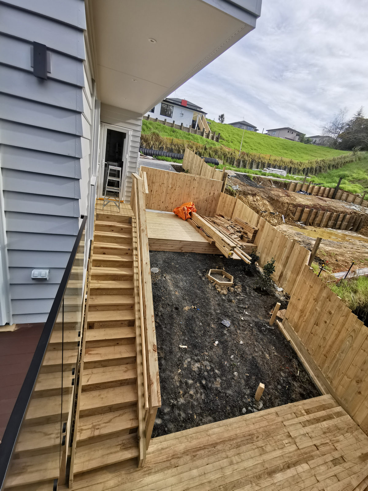 External timber stair running down beside the house to a retained bank, Albany