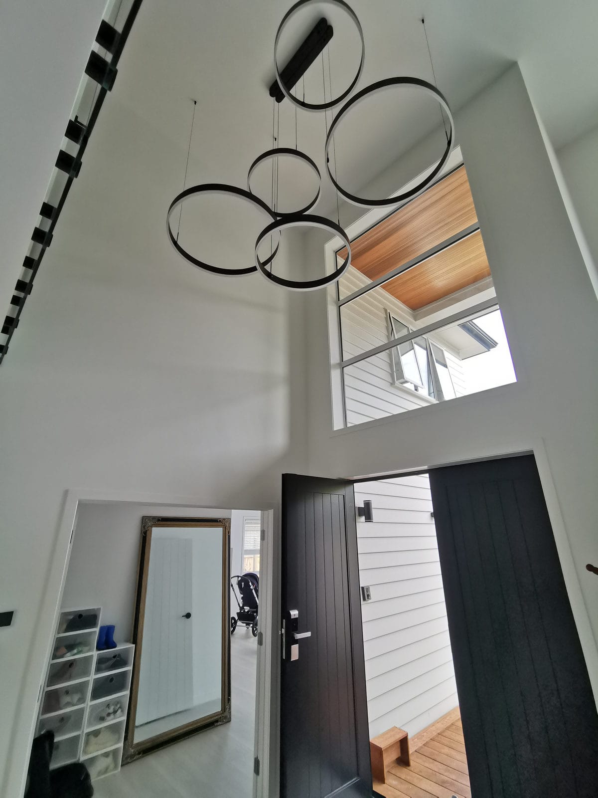 Double-height entry with a circular pendant light and the front door below, Albany