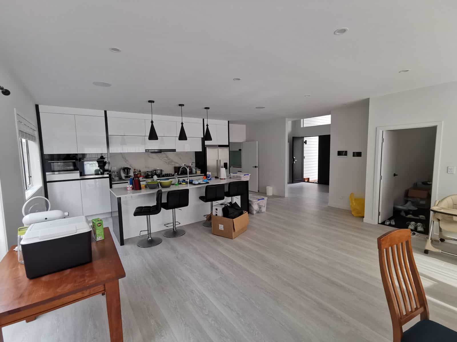 Open-plan kitchen and dining with pendant lights over the island bench, Albany