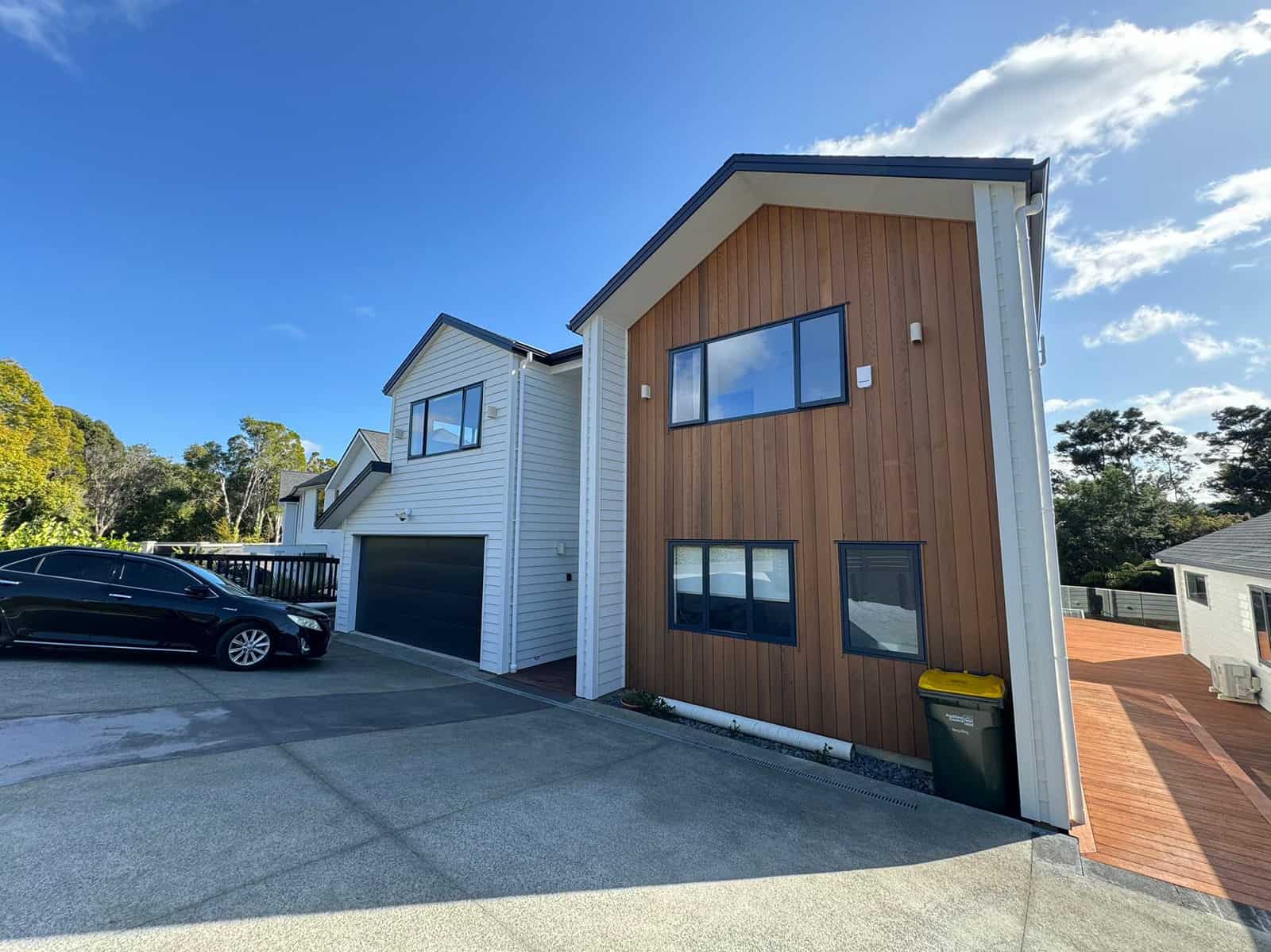 Front of the house with timber cladding, double garage and a car on the drive, Greenhithe
