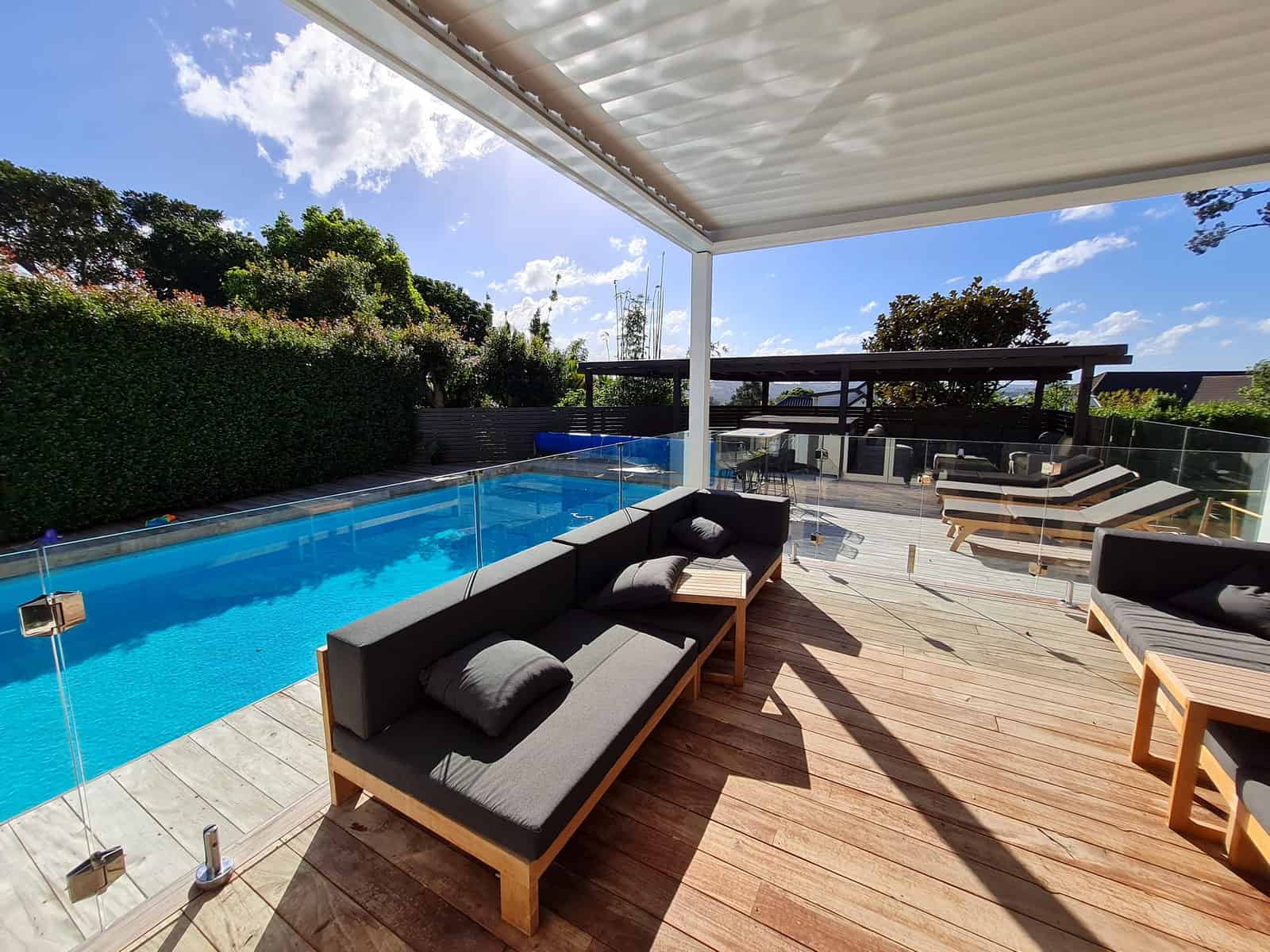 Pool shelter with a modular lounge beside the swimming pool and timber deck, Greenhithe