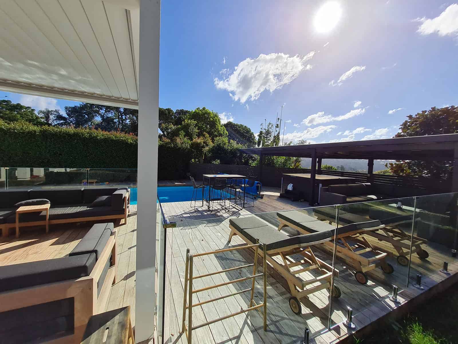 Looking out from under the louvre roof to the pool, deck and hedge beyond, Greenhithe