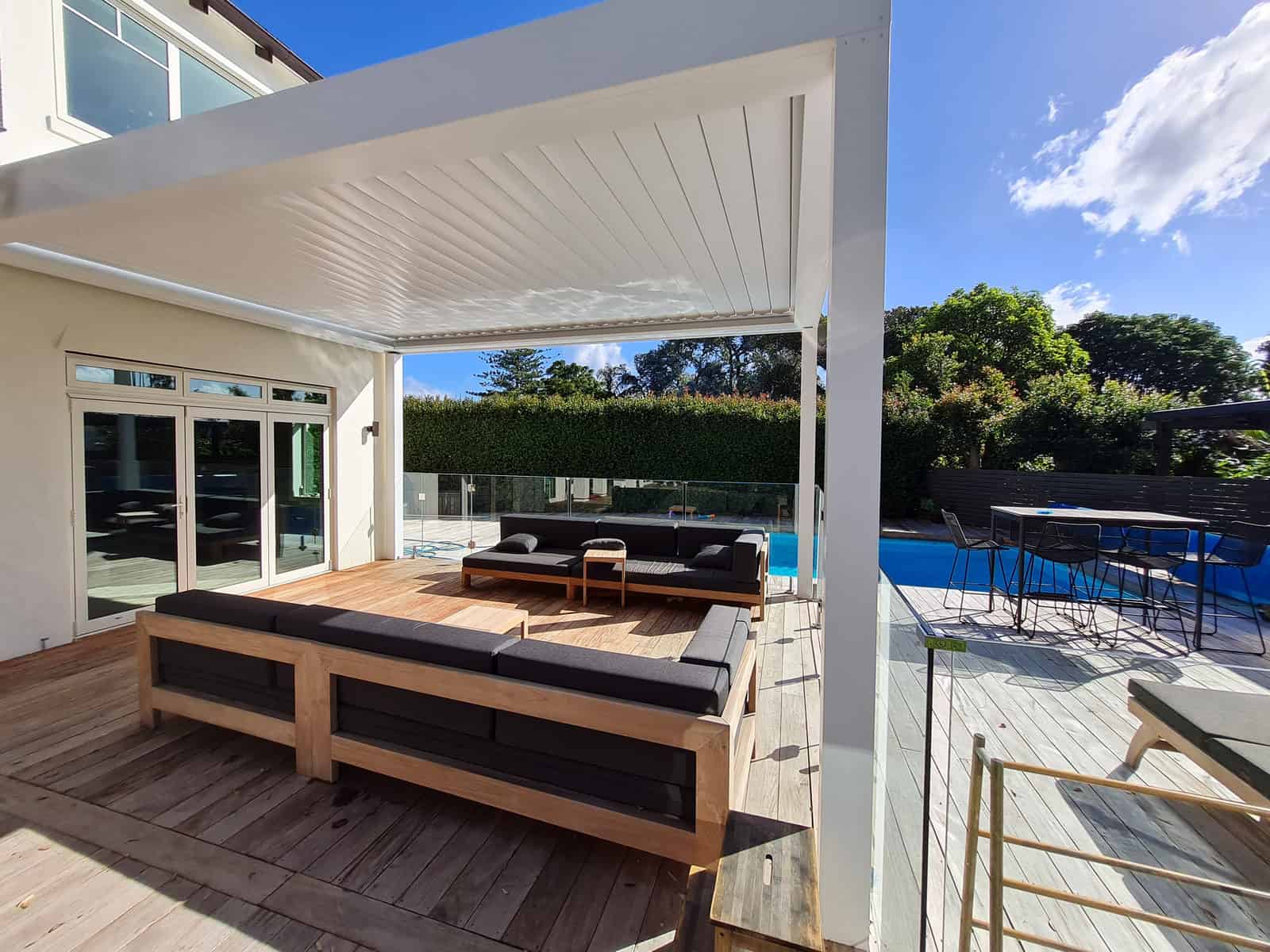 Louvre pool shelter with lounge seating and a bar-height table beside the pool, Greenhithe