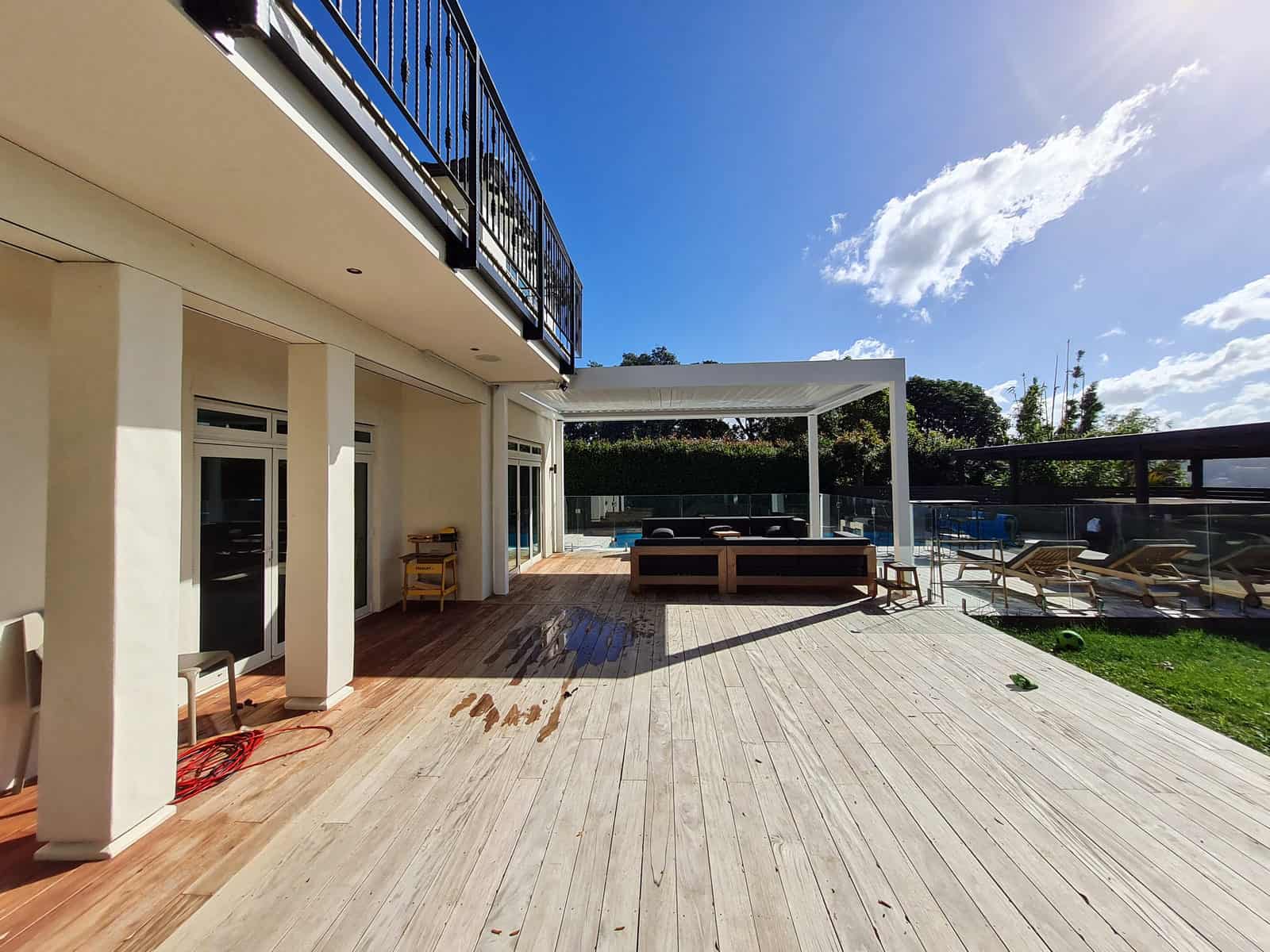 Deck and pool shelter with the upper-level balcony of the house above, Greenhithe