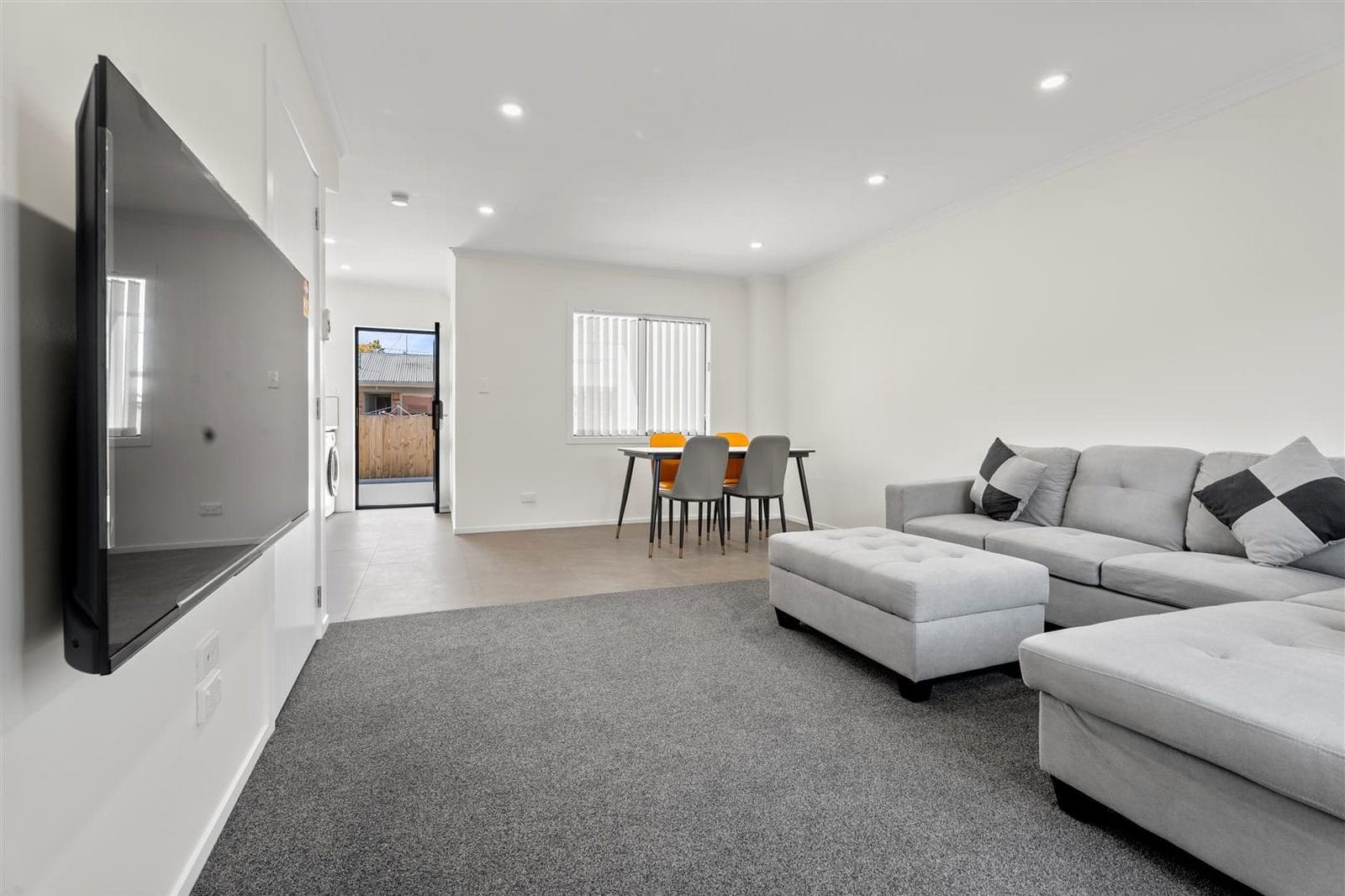 Open-plan living and dining in a terraced unit with a wall-mounted television, Hamilton