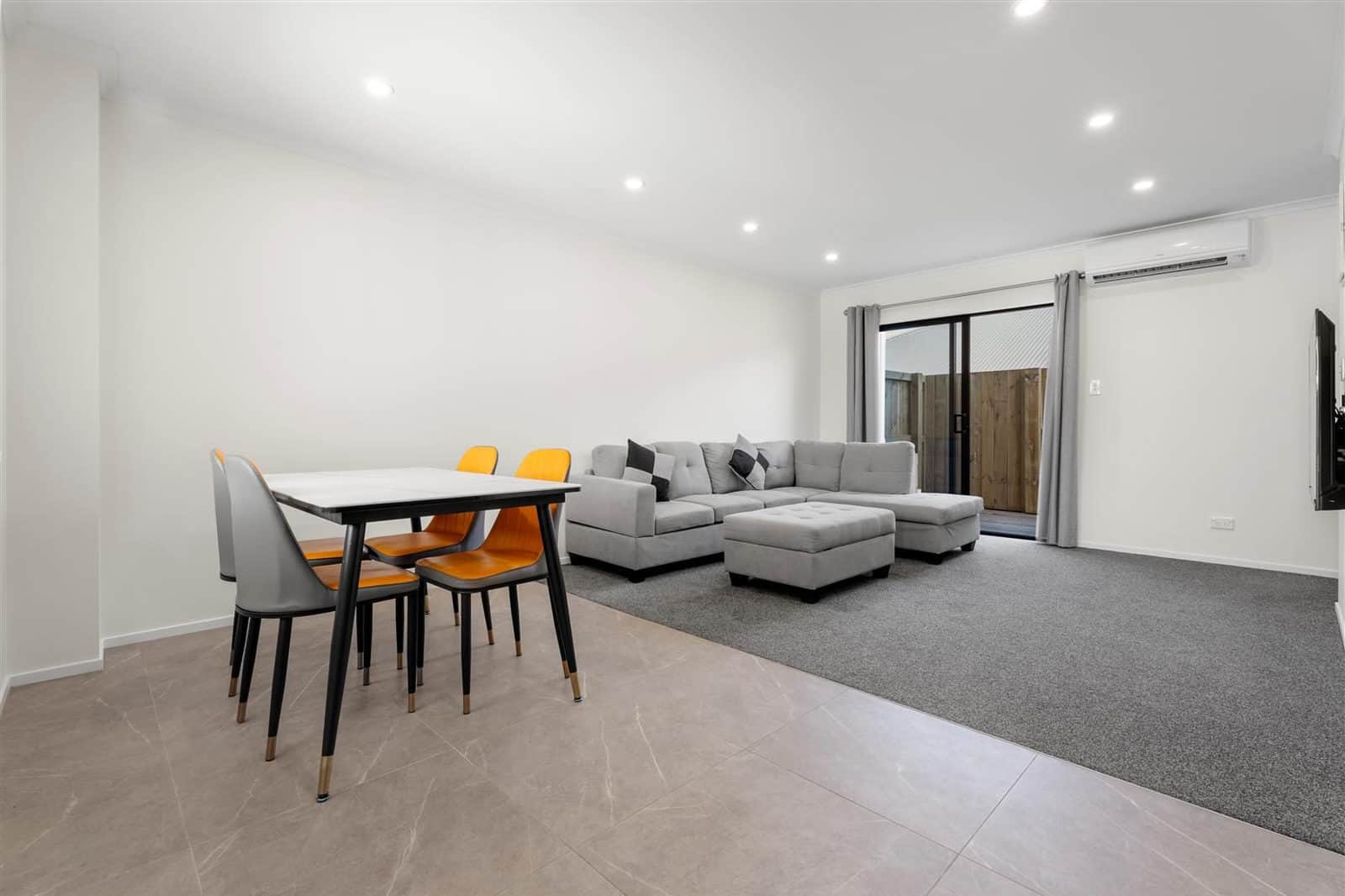 Dining table and lounge suite with a sliding door to the courtyard, Hamilton