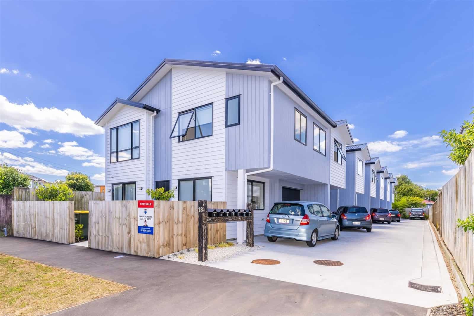 Terrace row of seven houses along a shared drive with parking bays, Hamilton