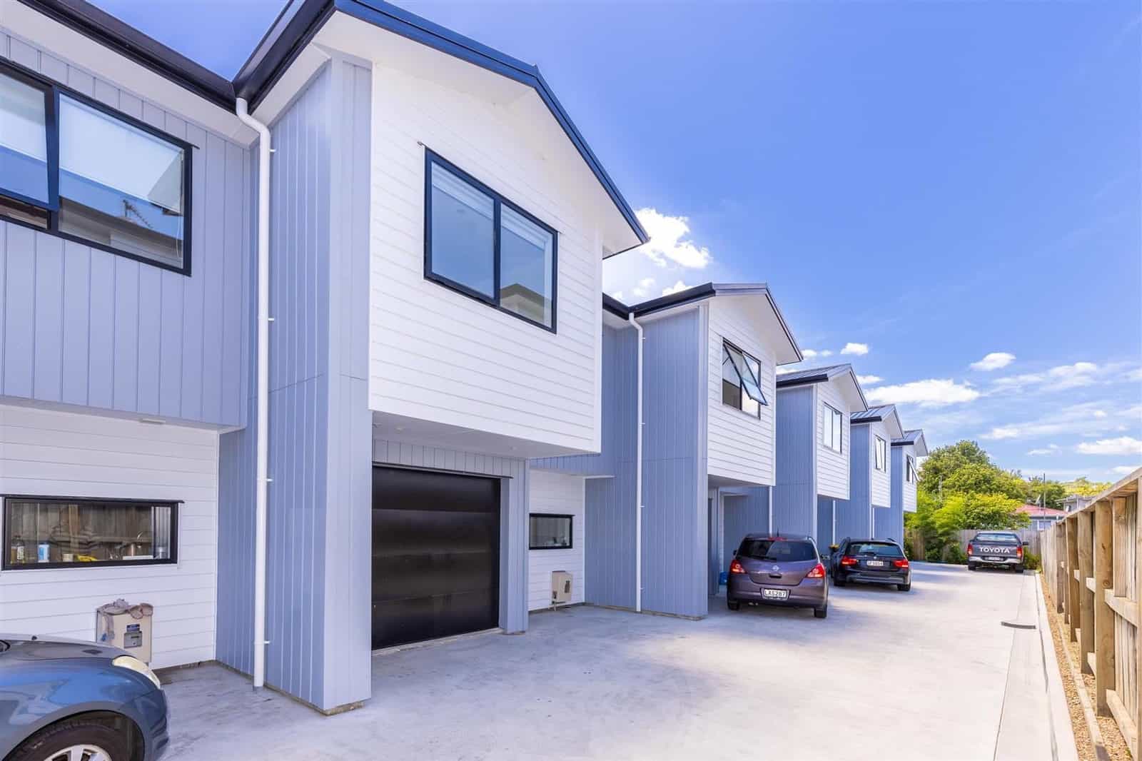 End unit of the terrace with its garage door and the drive running past, Hamilton