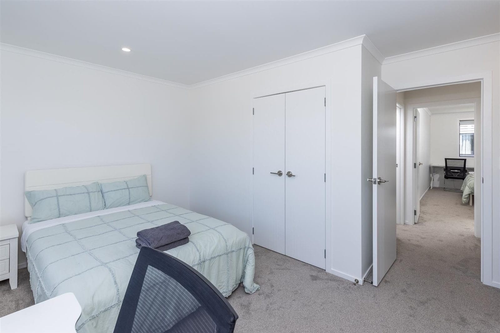 Bedroom with built-in wardrobes and a view through to the next room, Hamilton
