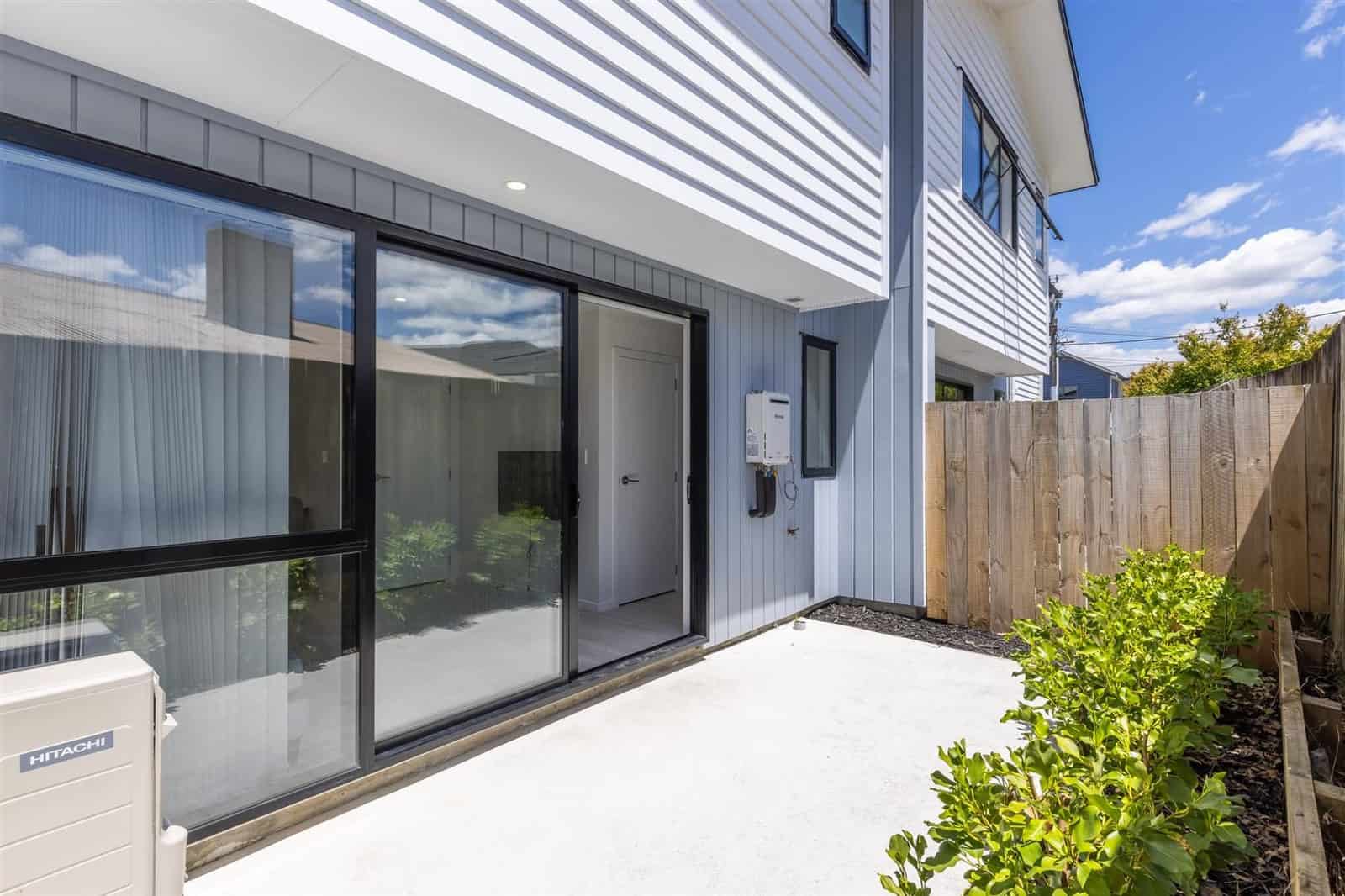 Paved courtyard beside the unit with a sliding door and new planting, Hamilton