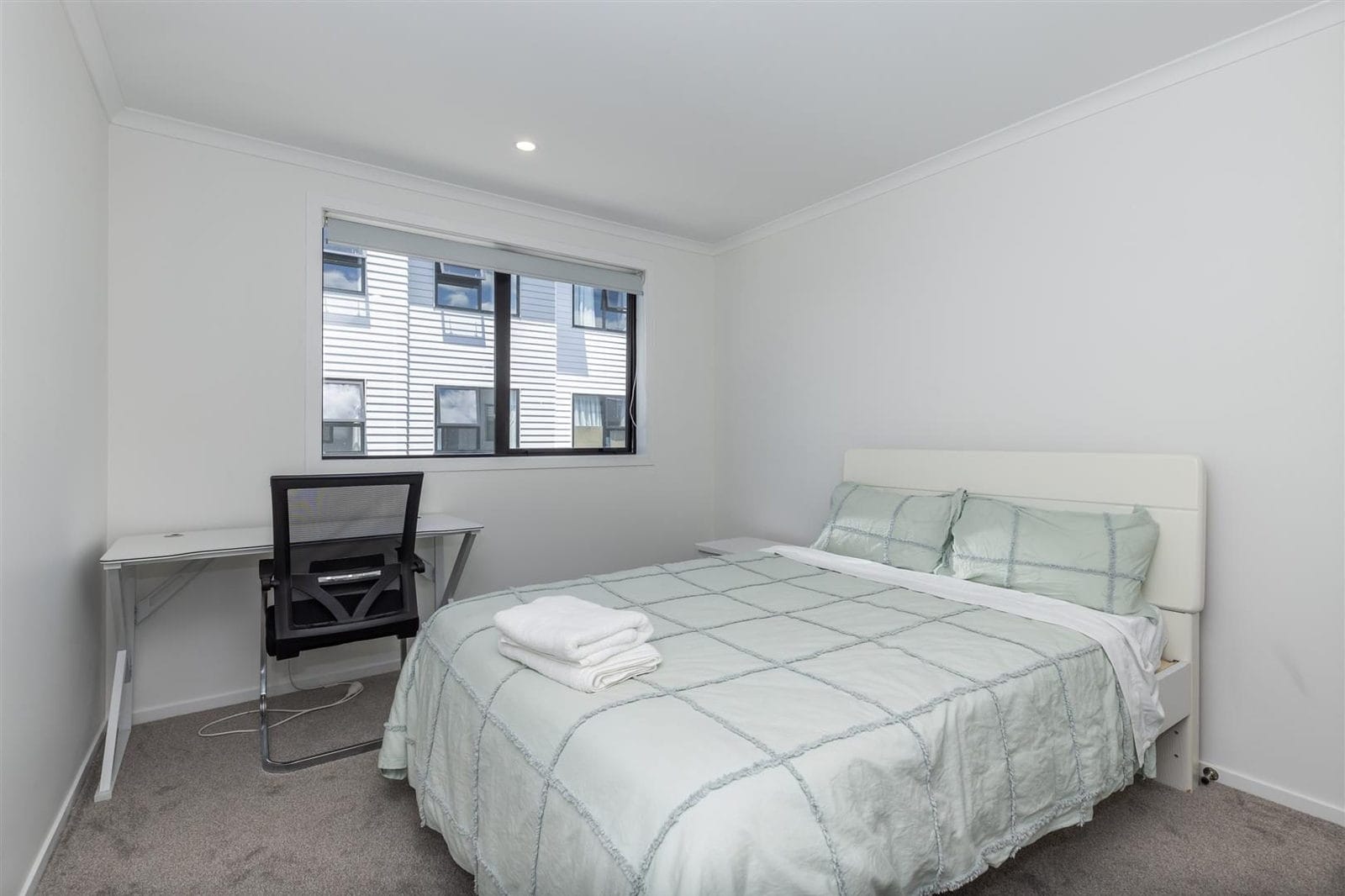 Bedroom with a desk beside the bed and windows on two walls, Hamilton