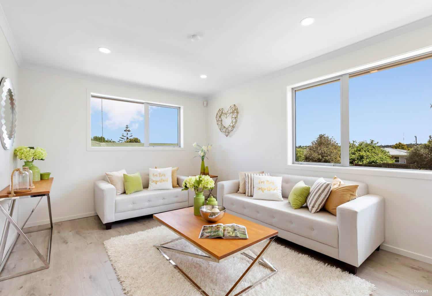 Living room with two white sofas, a timber coffee table and windows on two walls, Te Atatu South