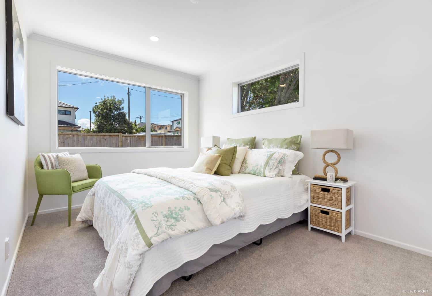 Bedroom with a green armchair and windows on two walls, Te Atatu South