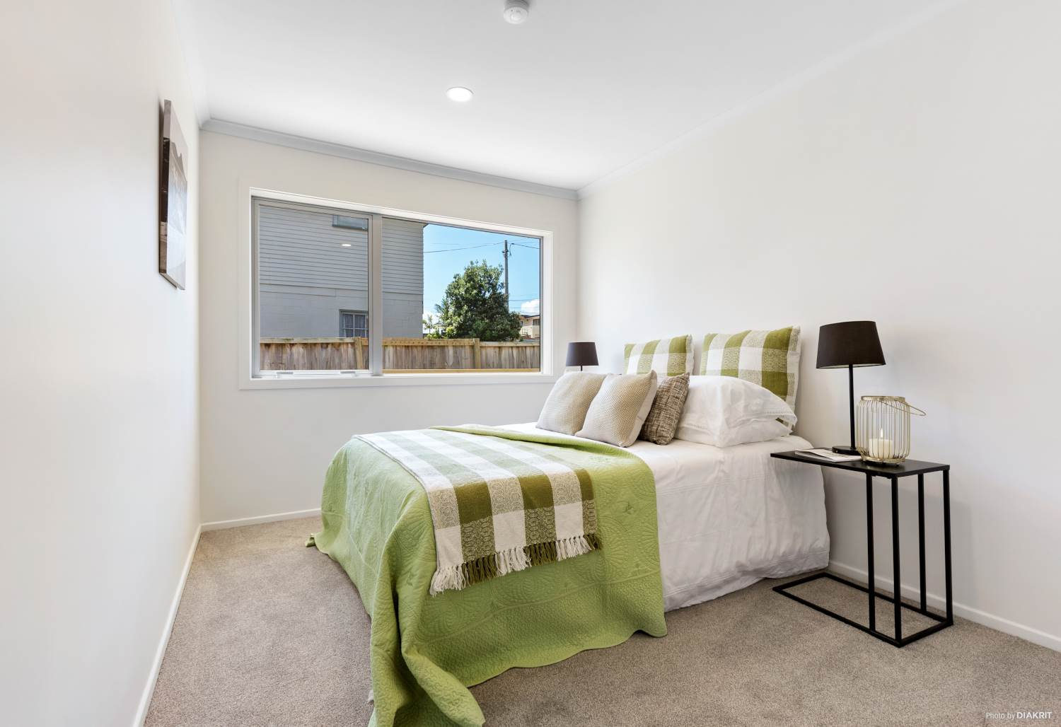 Bedroom with a green throw and a bedside lamp, Te Atatu South