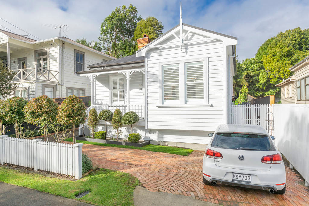 White villa with a bullnose verandah behind a picket fence, Kingsland