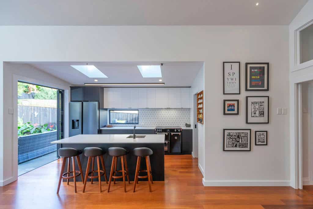 Kitchen with a dark island, bar stools and skylights overhead, Kingsland