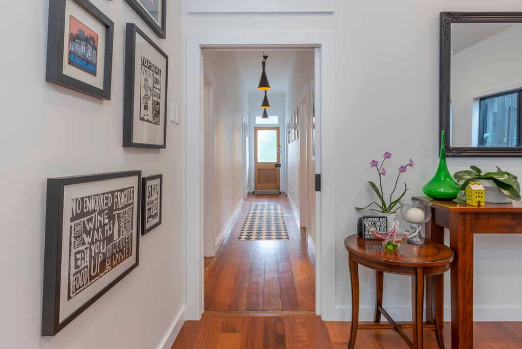 Villa hallway with timber floors and a framed picture wall looking through to the rear, Kingsland