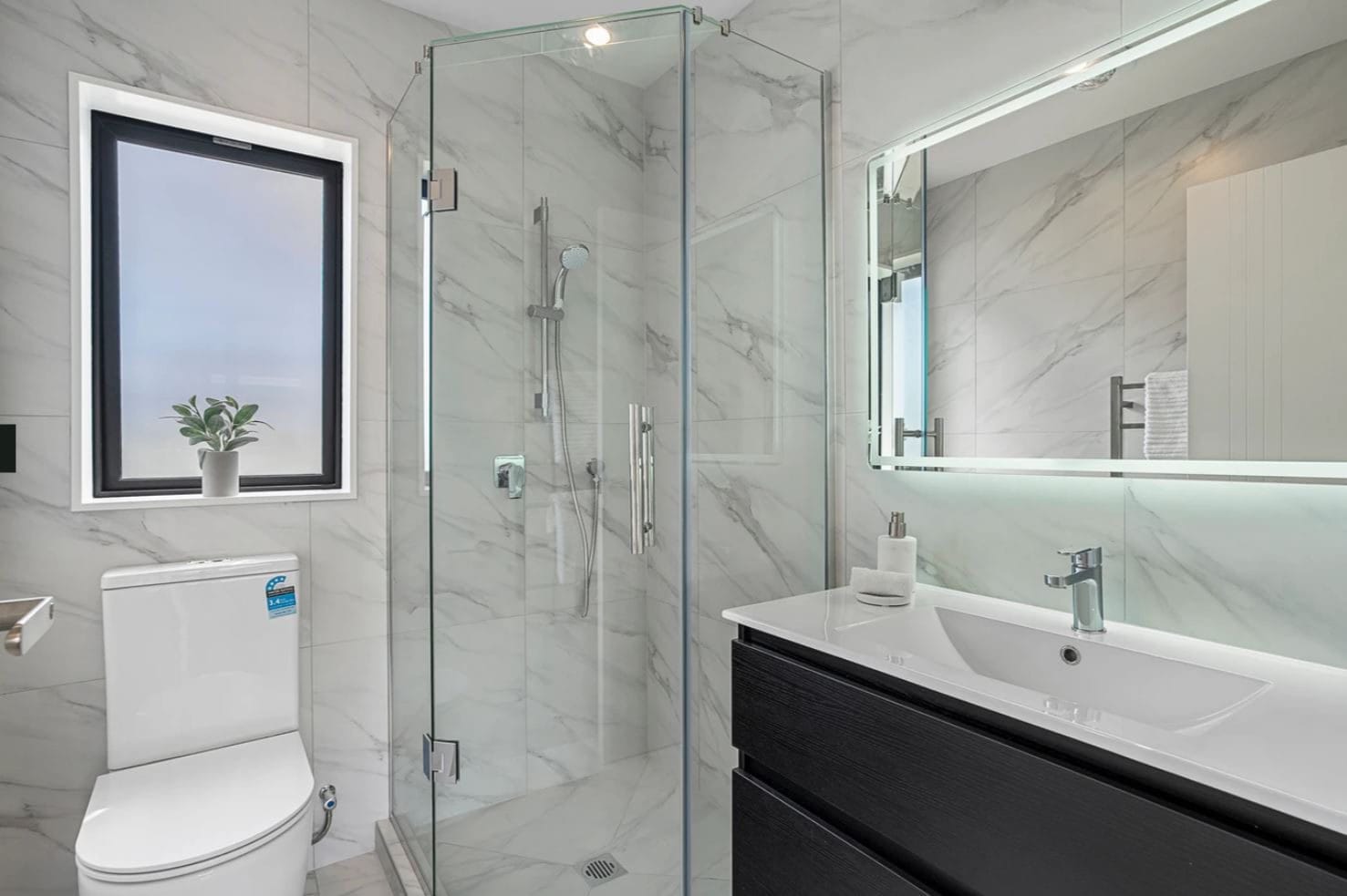 Bathroom with a glazed corner shower, wall-hung vanity and marble-look tiling, Lynfield