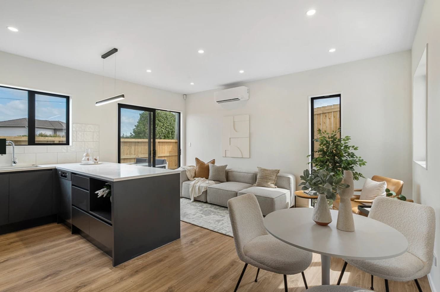Open-plan kitchen, dining and living with a dark island bench, Lynfield
