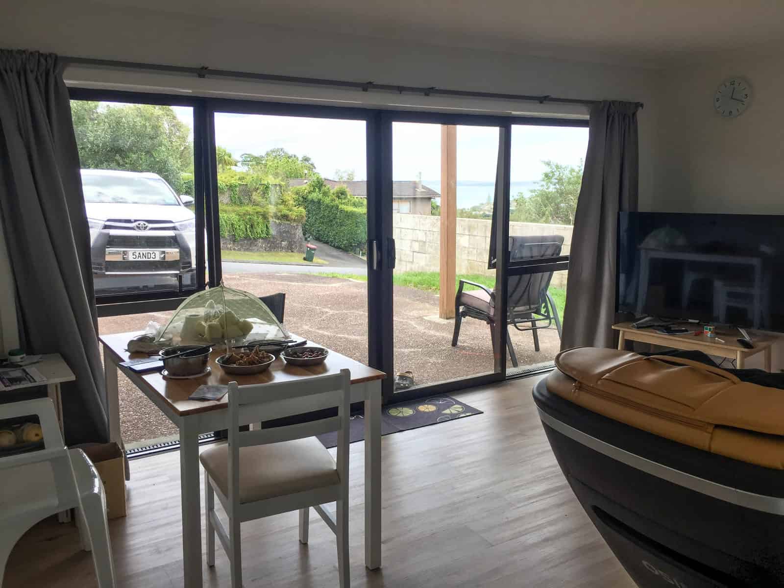 Existing dining area looking out through sliding doors to the driveway, Mairangi Bay
