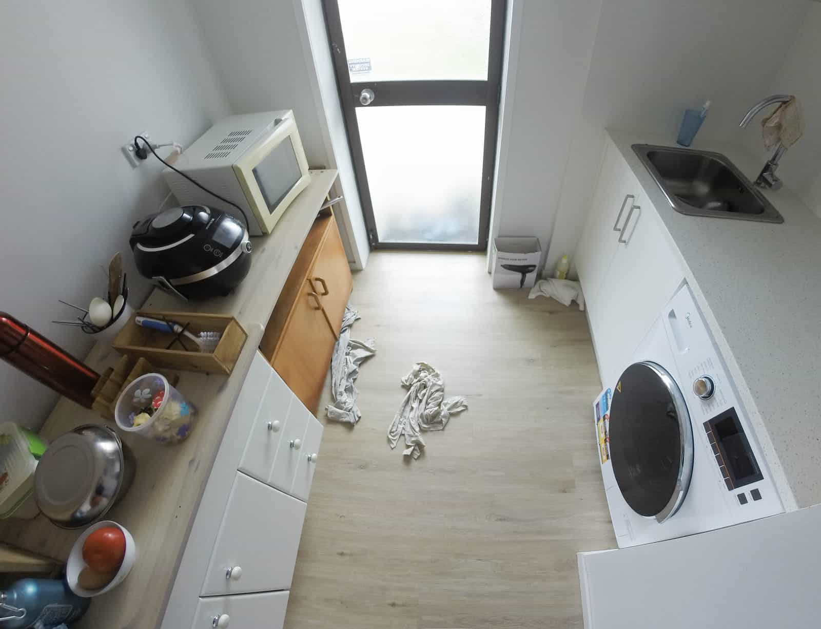Existing laundry and kitchenette with a washing machine and microwave, Mairangi Bay