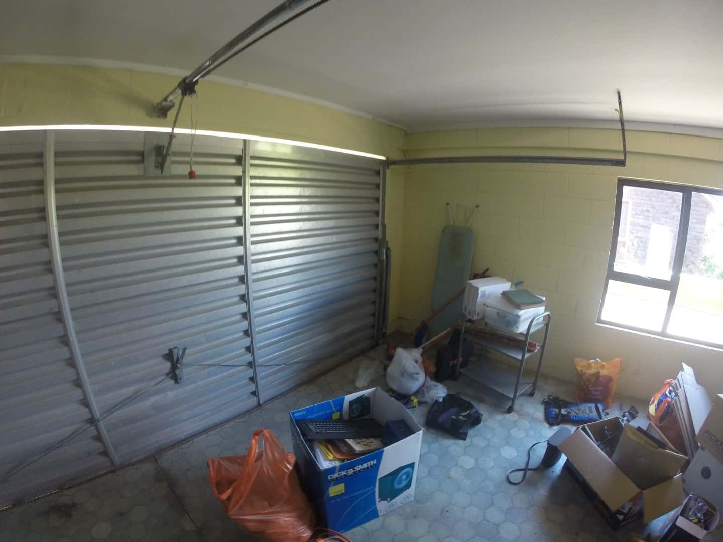 Existing garage with a roller door, stored boxes and a side window, Mairangi Bay