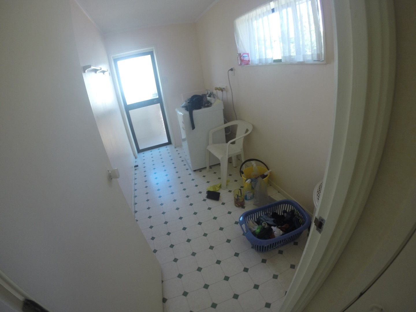 Existing laundry with a patterned vinyl floor and a tall window, Mairangi Bay