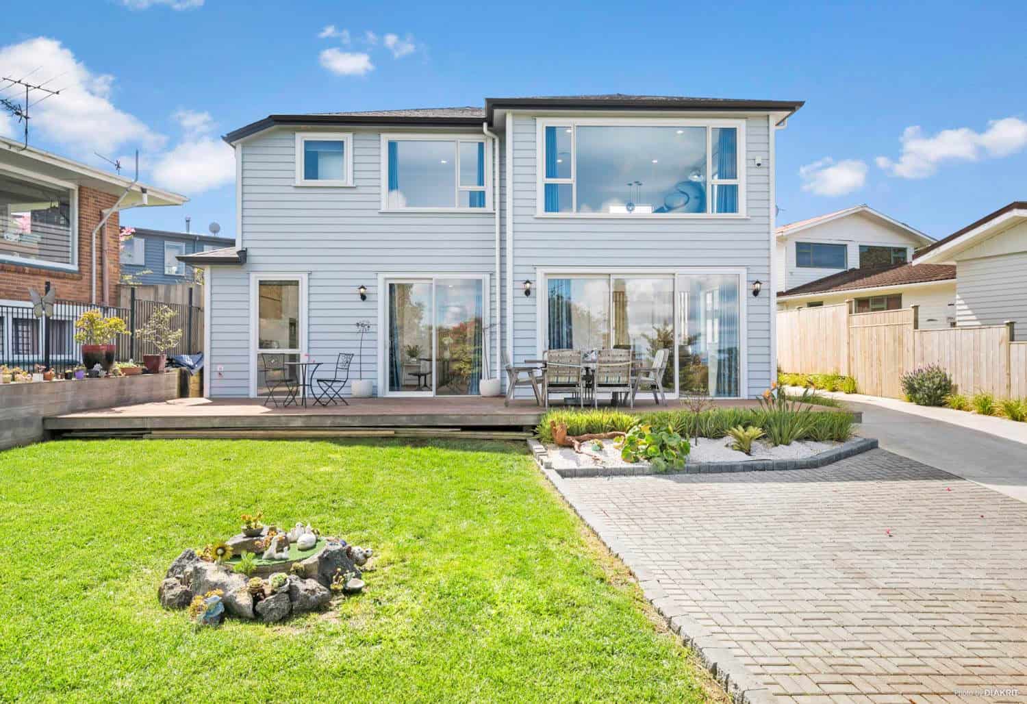 Rear elevation with sliding doors onto the terrace and lawn, Mairangi Bay