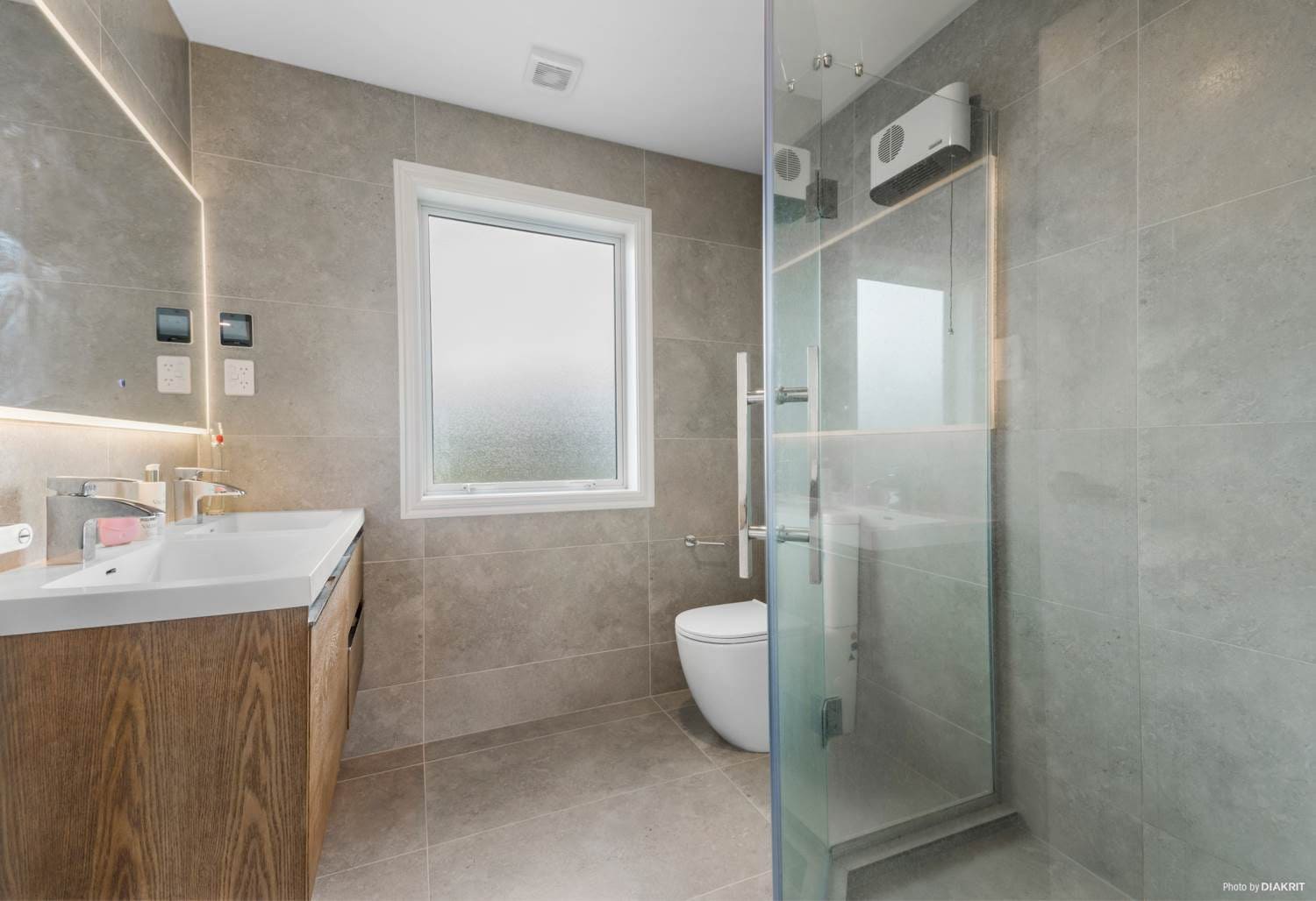 Bathroom with a timber vanity, wall-hung toilet and walk-in shower, Mairangi Bay