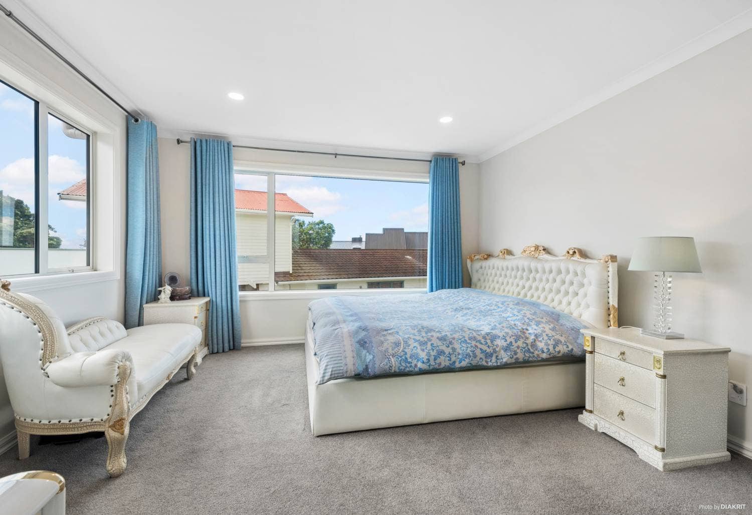 Bedroom with an upholstered bedhead and a wide window, Mairangi Bay