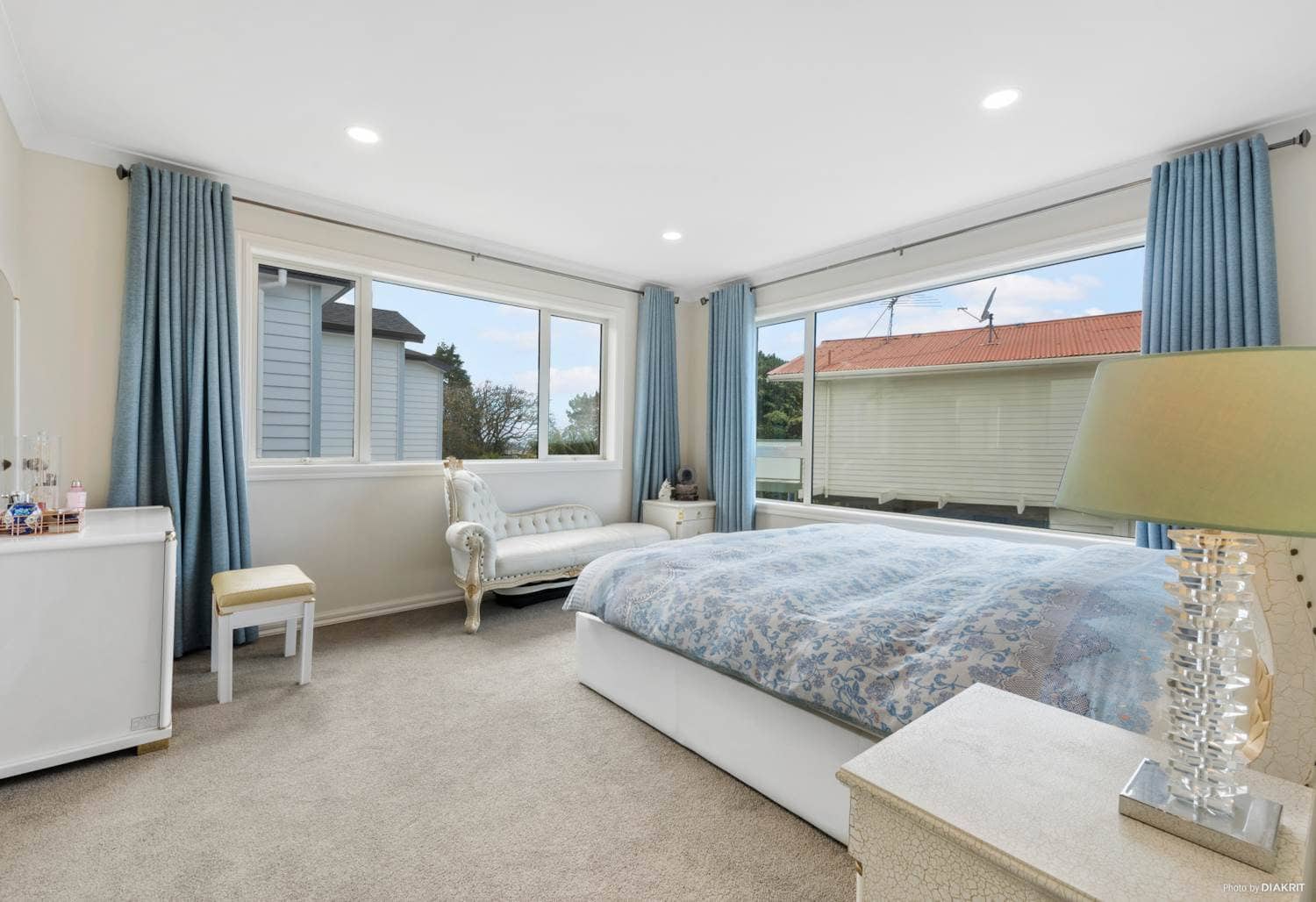 Main bedroom with windows on two walls looking out over the neighbourhood, Mairangi Bay