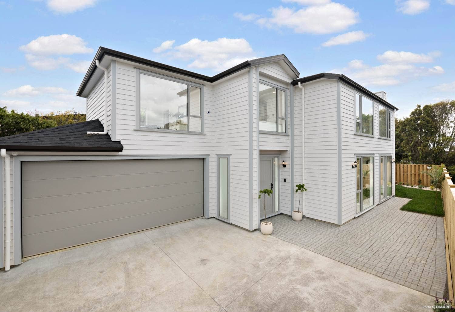 Front of the house with a double garage and paved drive, Mairangi Bay