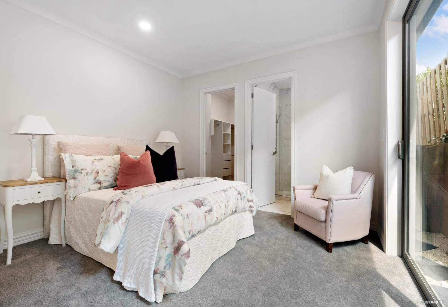 Bedroom with a sliding door to the courtyard and an armchair, Mairangi Bay