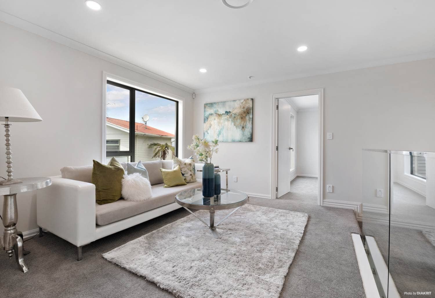 Upper living area with a sofa and a glass balustrade at the stair, Mairangi Bay