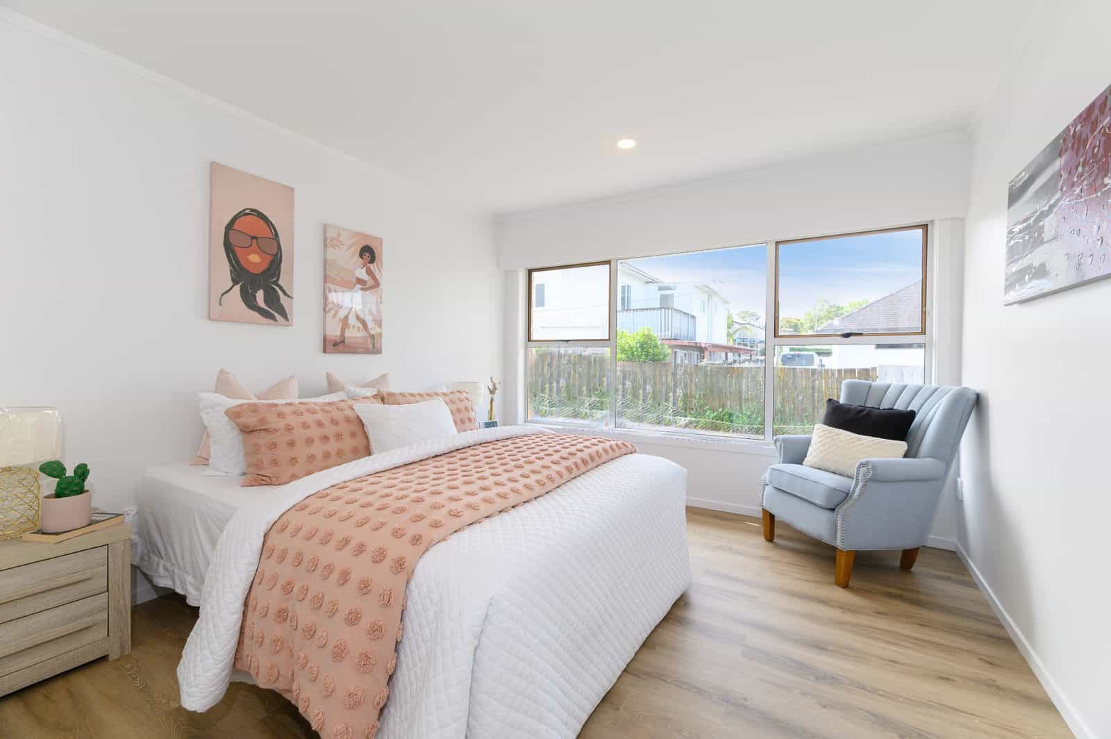 Bedroom with a wide window, armchair and timber-look flooring, Milford